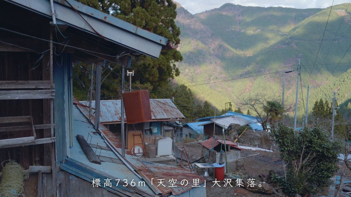 屋根越しに見える山並みと集落