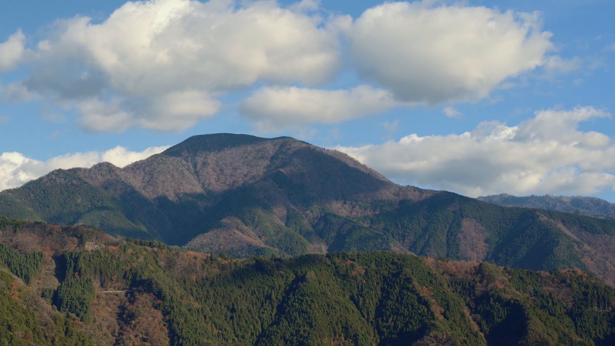 青空と雲の下の山の頂