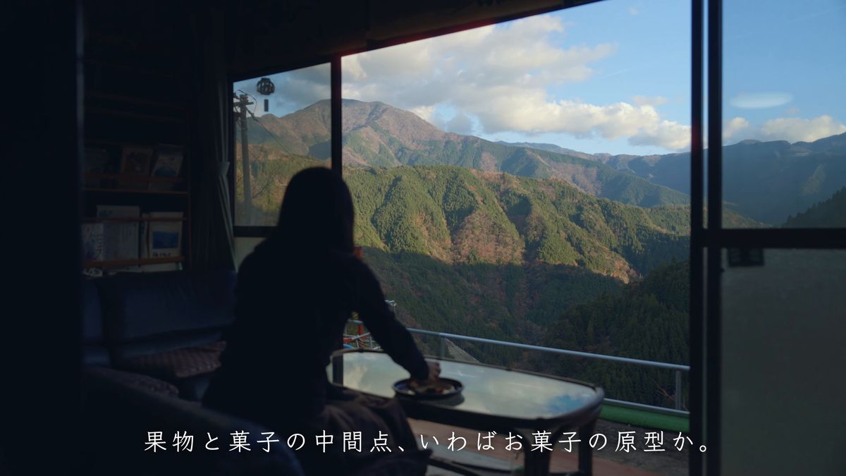 窓辺のテーブルで山を眺める後ろ姿