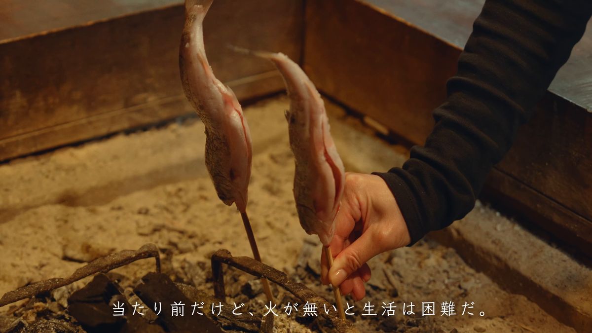 竹串に刺した二匹のヤマメを持つ手元