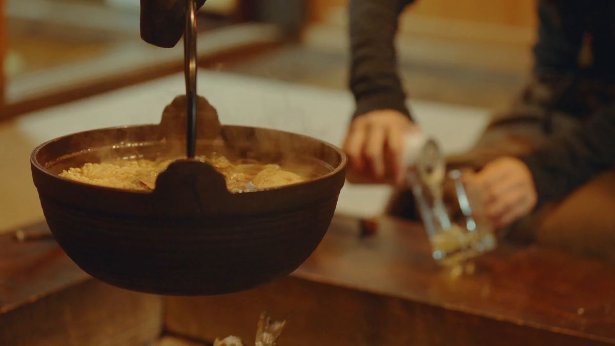 鍋のそばでビールを注ぐ手元