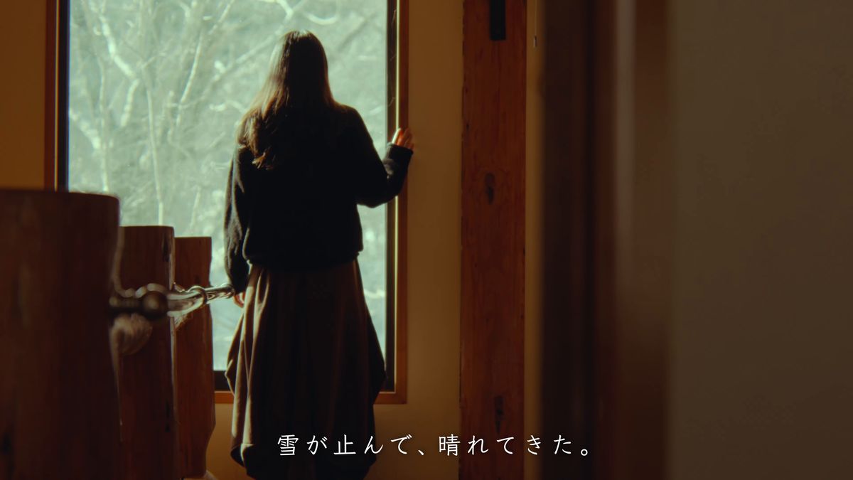 雪景色の窓辺に立つ後ろ姿