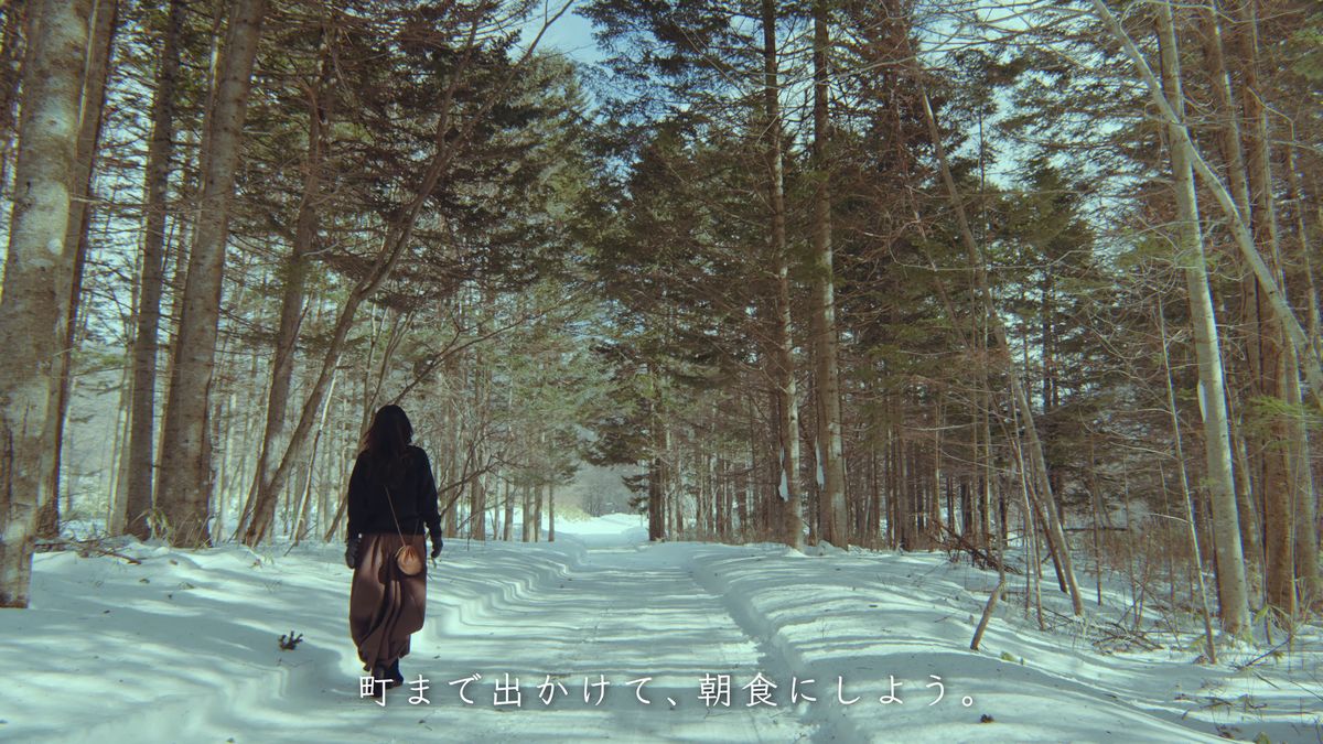 雪の林道を歩く後ろ姿