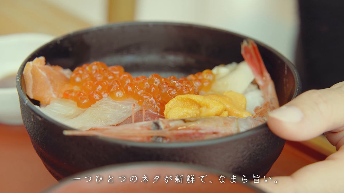 手に持った海鮮丼のサーモンとほたて