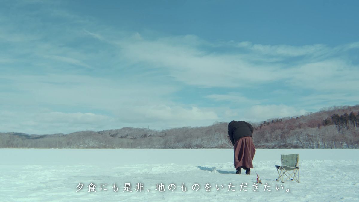 凍った湖の上に立つ後ろ姿と折りたたみの椅子