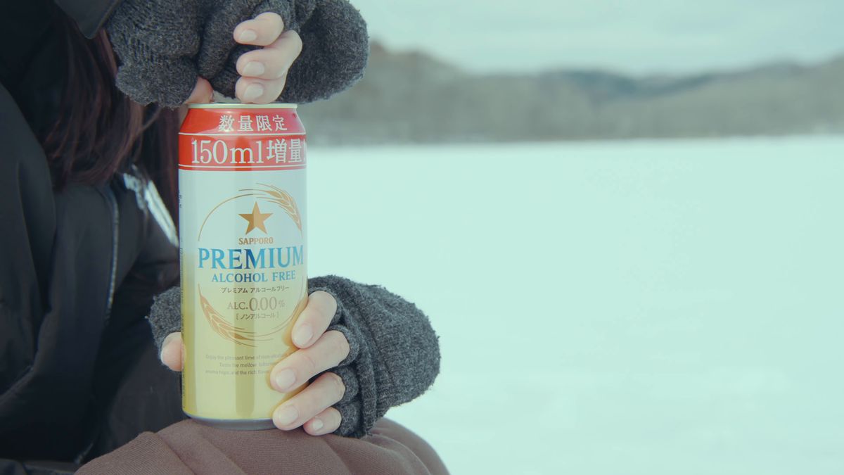 手袋の手で持つノンアルコールビールの缶