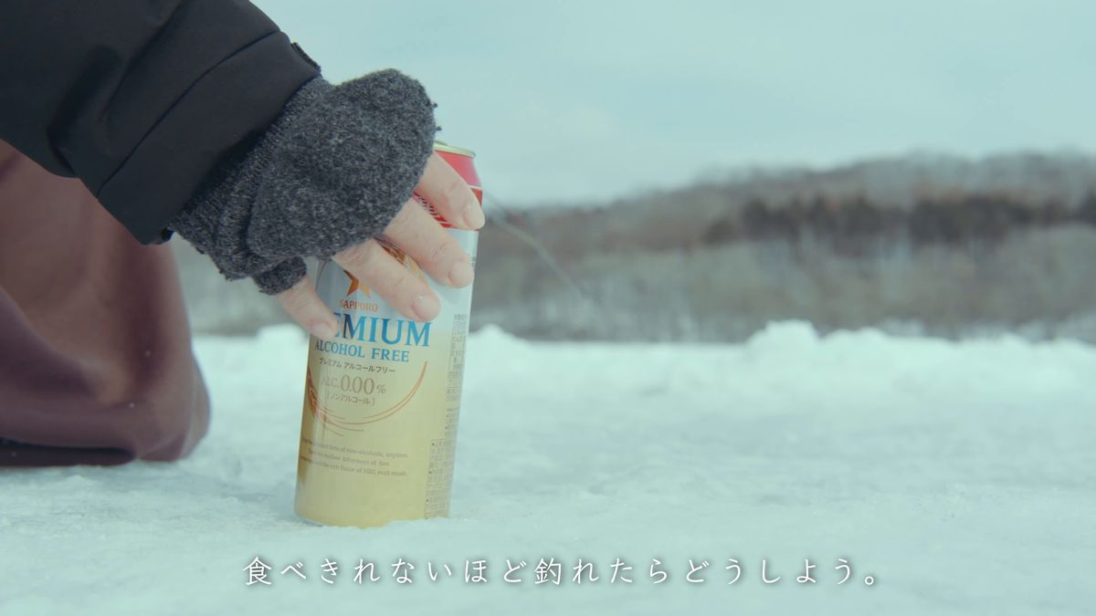 雪の上に缶を置く手元
