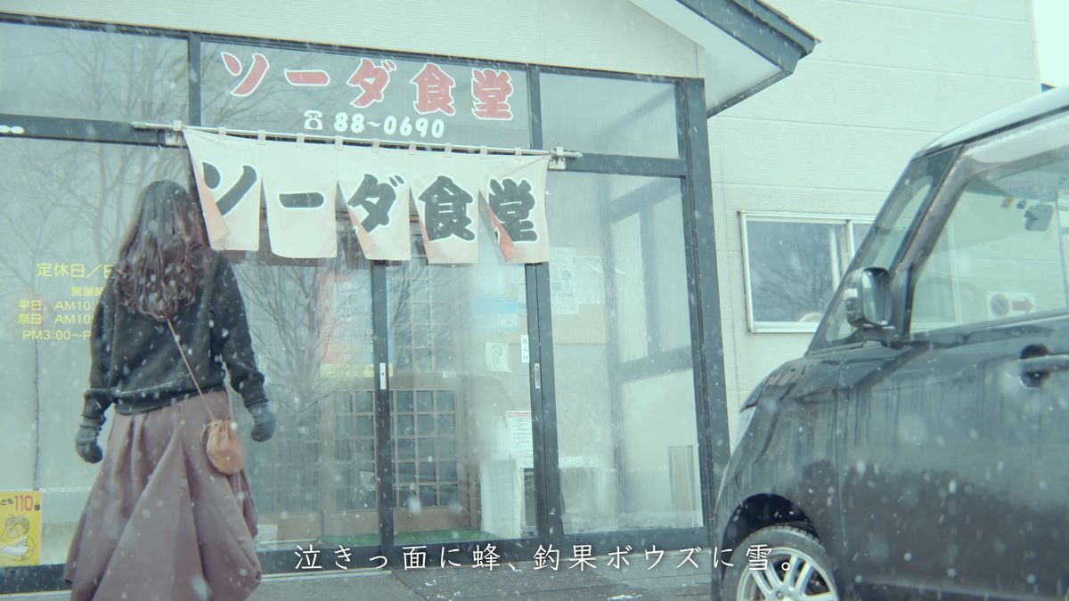のれんのかかった食堂の店先と歩く後ろ姿