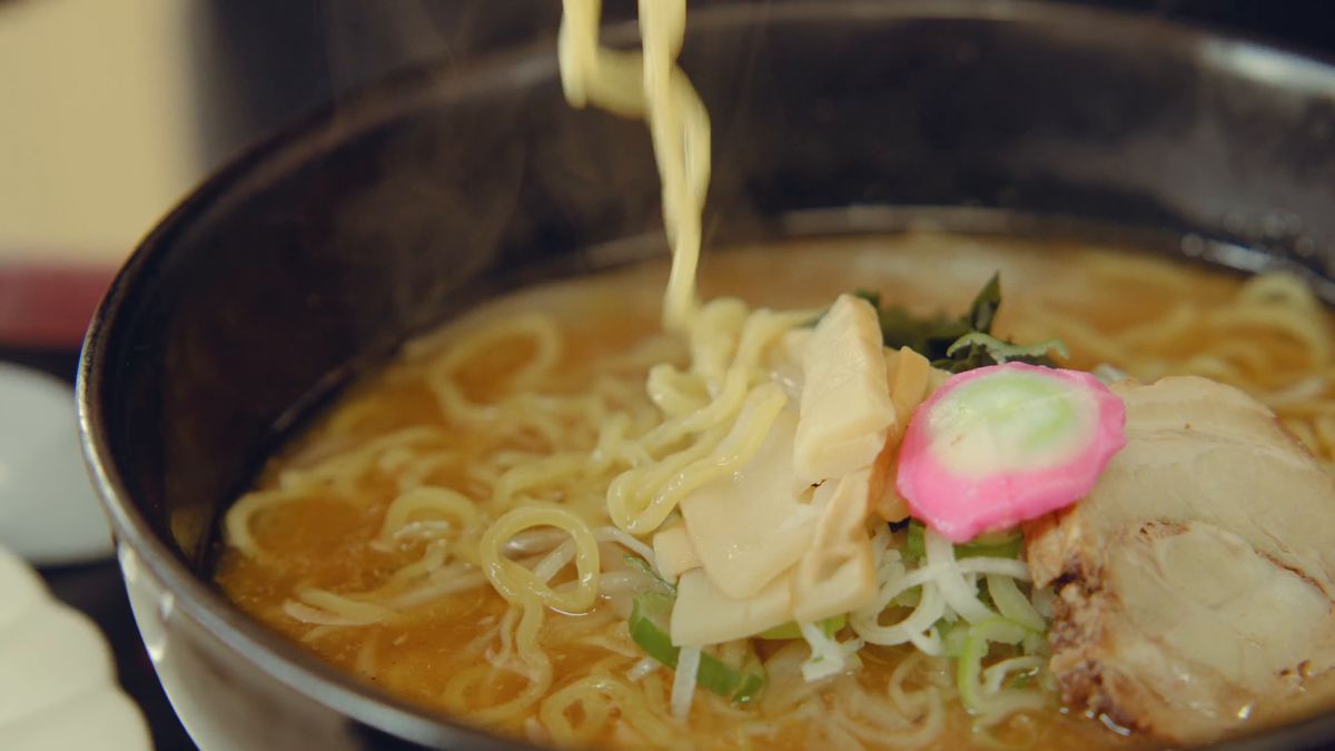 箸で持ち上げた縮れ麺
