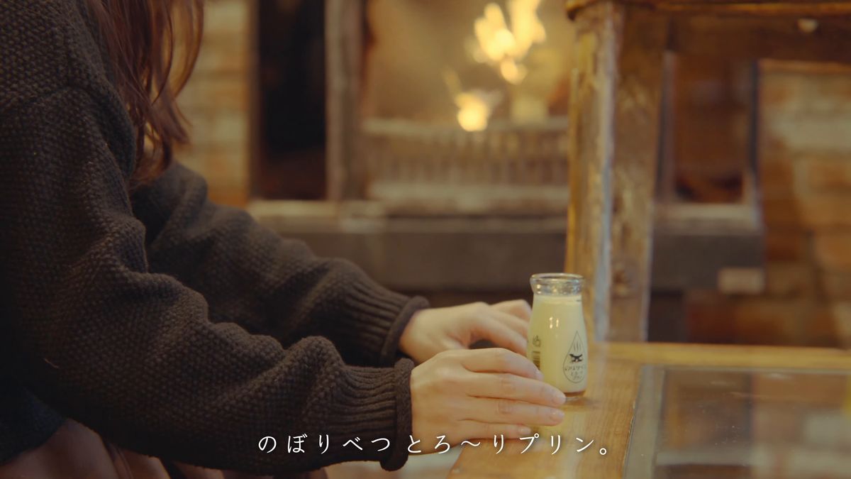 暖炉のそばで瓶のプリンを手にする
