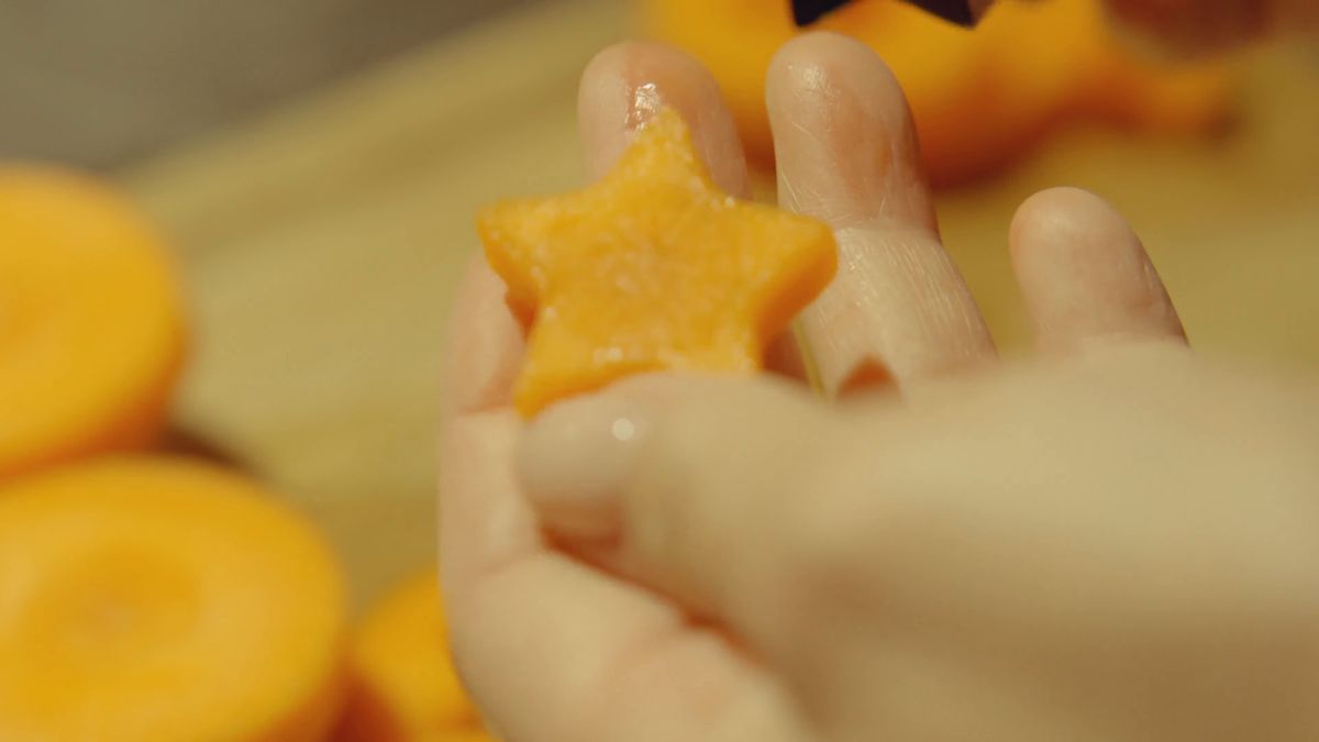 星形のにんじんをつまむ指先