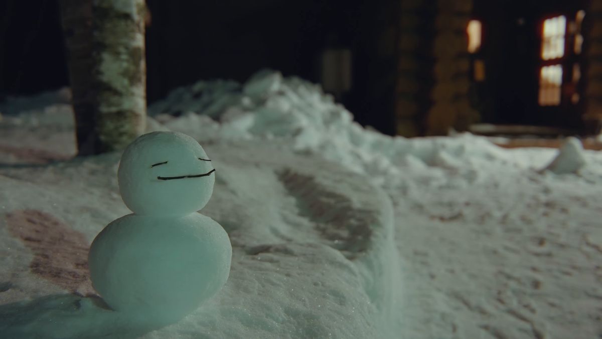 夜の雪の上の小さな雪だるま