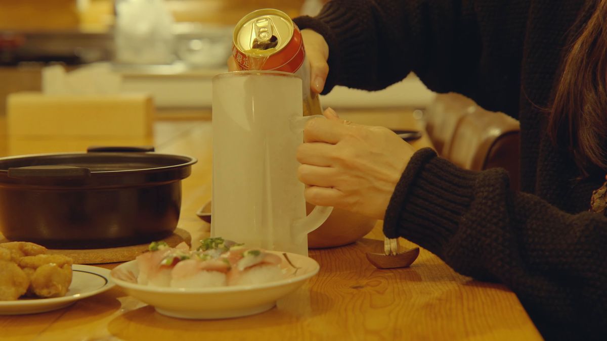 缶からグラスに注ぐ手元