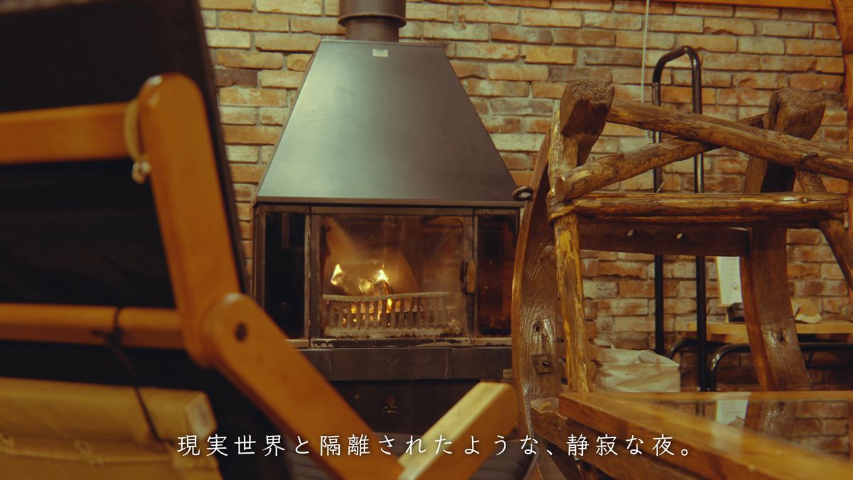 夜、椅子越しに見える暖炉の小さな火