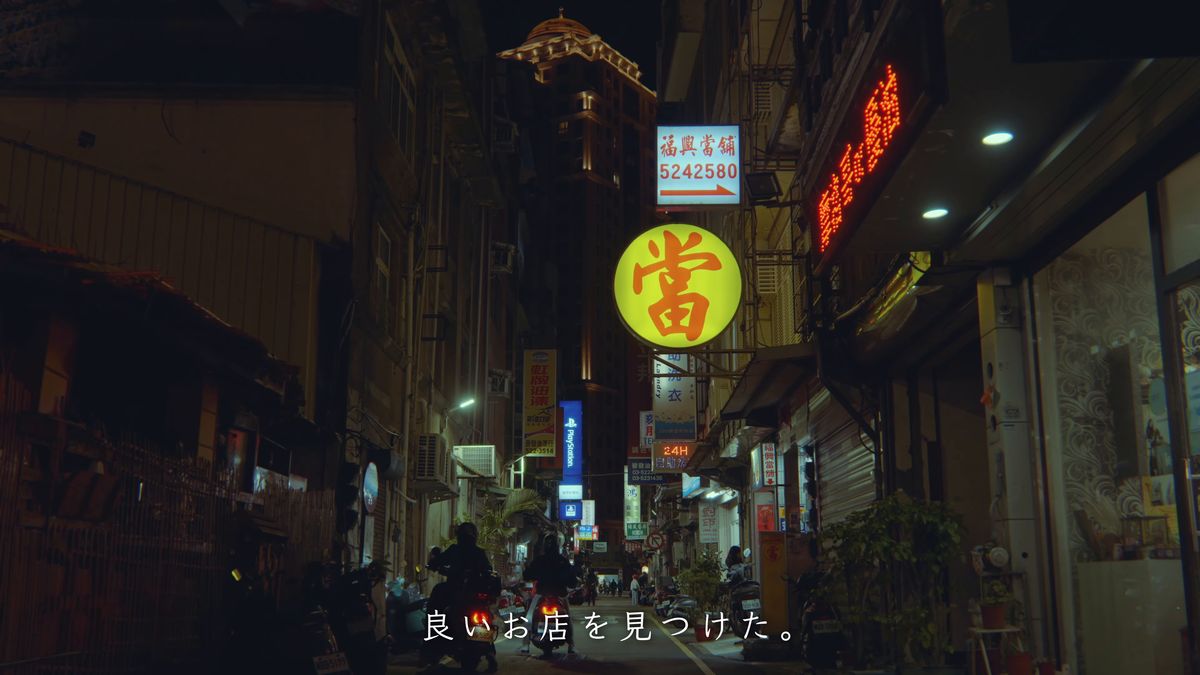 質屋の看板が光る夜の通り