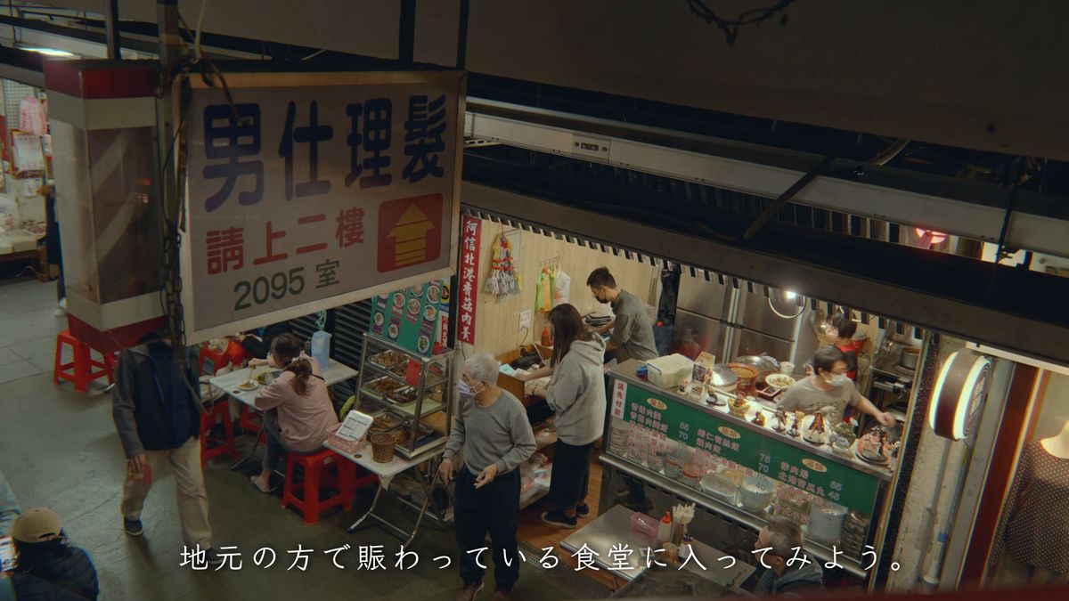 理髪店の看板の下で賑わう食堂