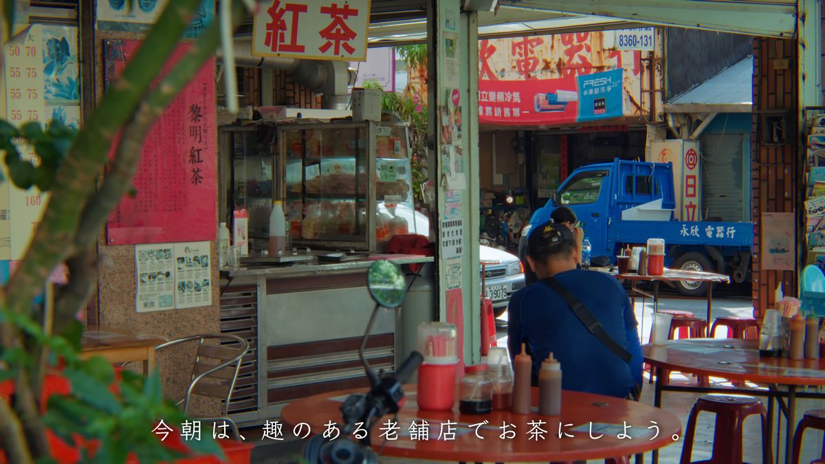 「黎明紅茶」の看板が下がる店先と、向かいの通り