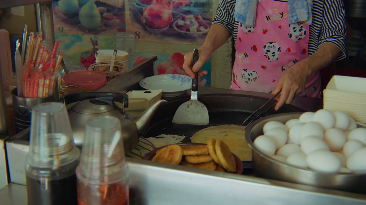 鉄板で卵料理を焼く店の人の手元
