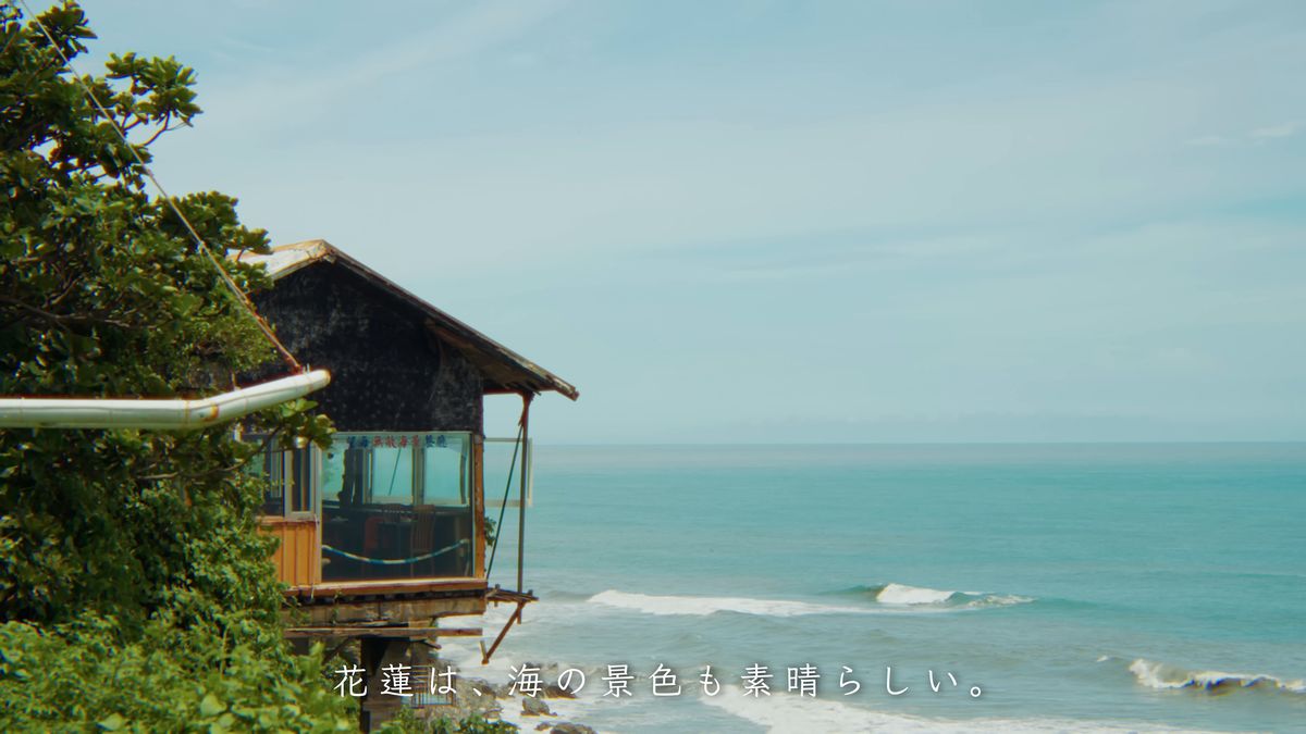 崖に張り出した木の小屋と白い波