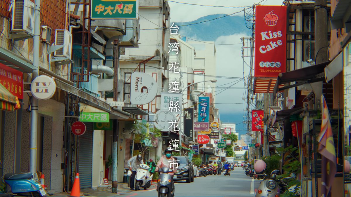 看板の並ぶ通りの先にそびえる山