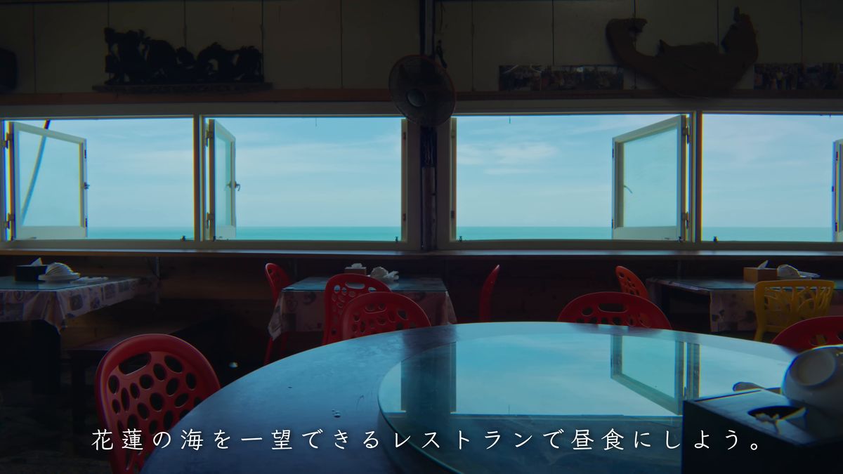 窓の向こうに海が広がる店内と赤い椅子