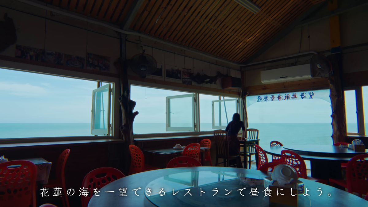 円卓の並ぶ店内と、窓辺の後ろ姿