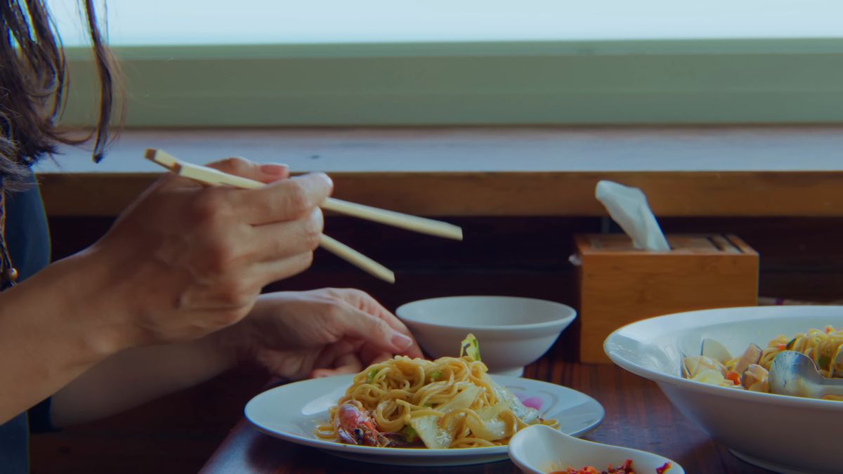 窓辺で焼きそばを食べる手元