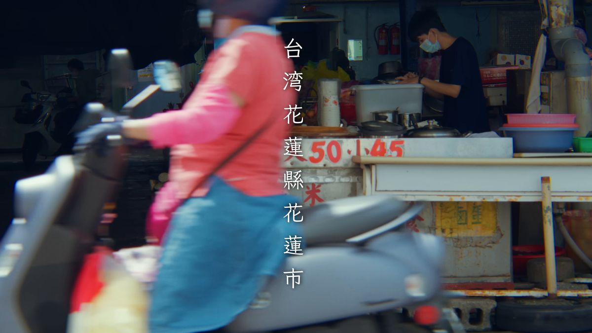 屋台の前を走り抜けるスクーター