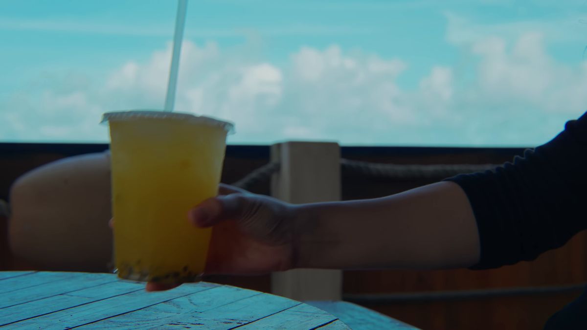 檸檬ジュースのカップを手に取る