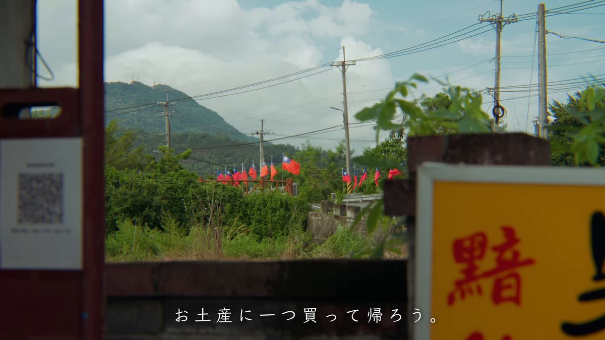 「黯然銷魂」の看板と、山の見える畑