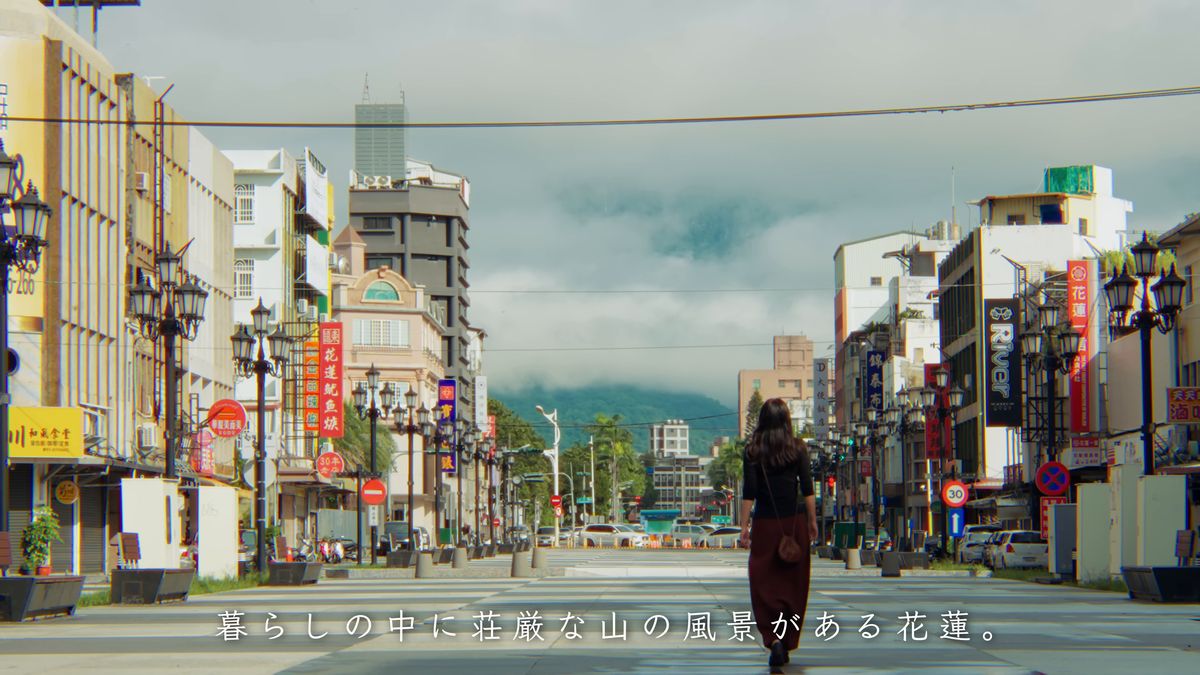 山に向かってのびる通りを歩く後ろ姿