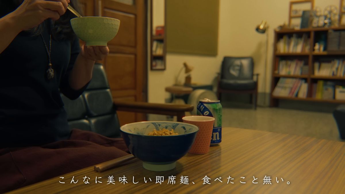 椀を手に麺を食べる
