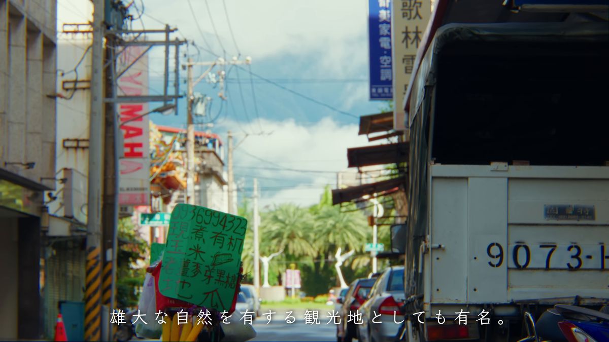 看板の並ぶ路地と、止まったトラックの荷台