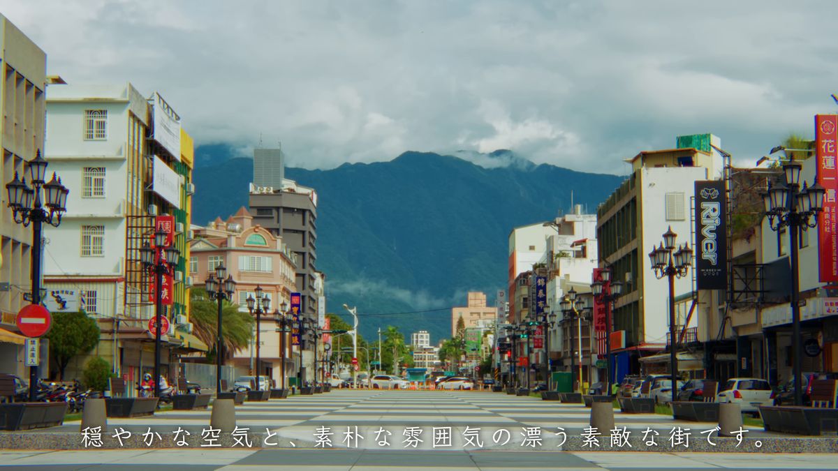 街の通りの先に広がる雲のかかった山