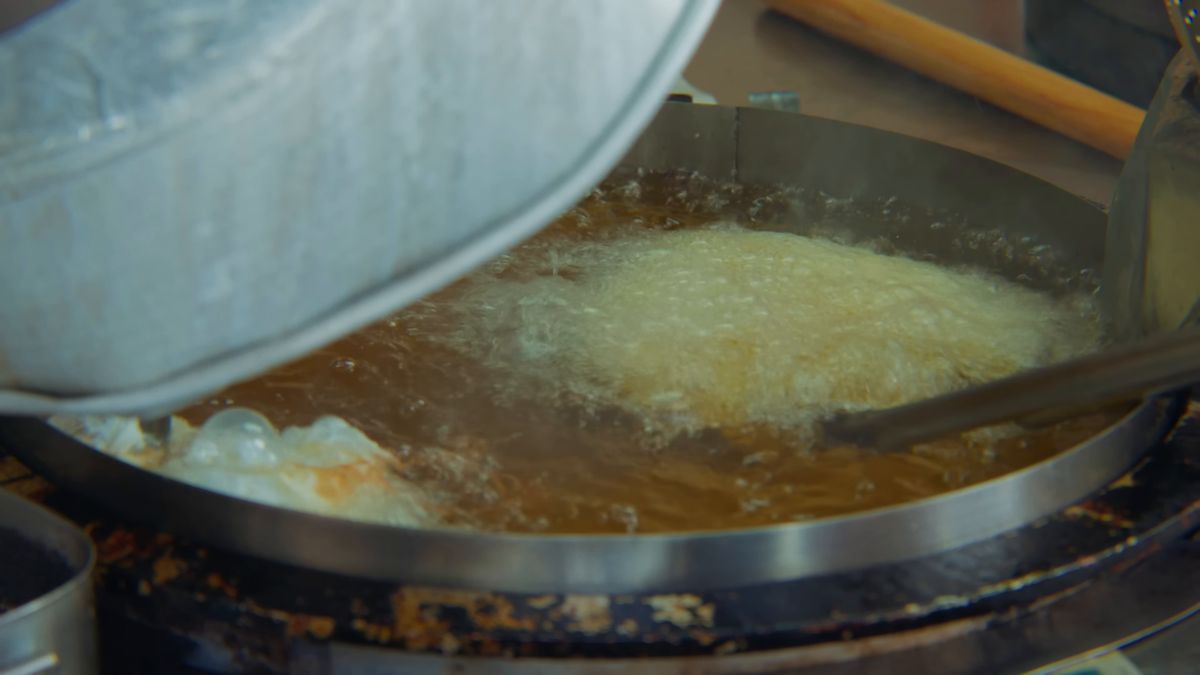 大鍋の油で生地を揚げる
