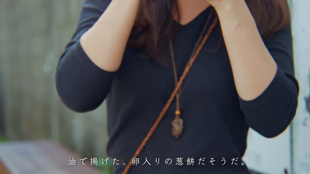 通りで葱餅をほおばる