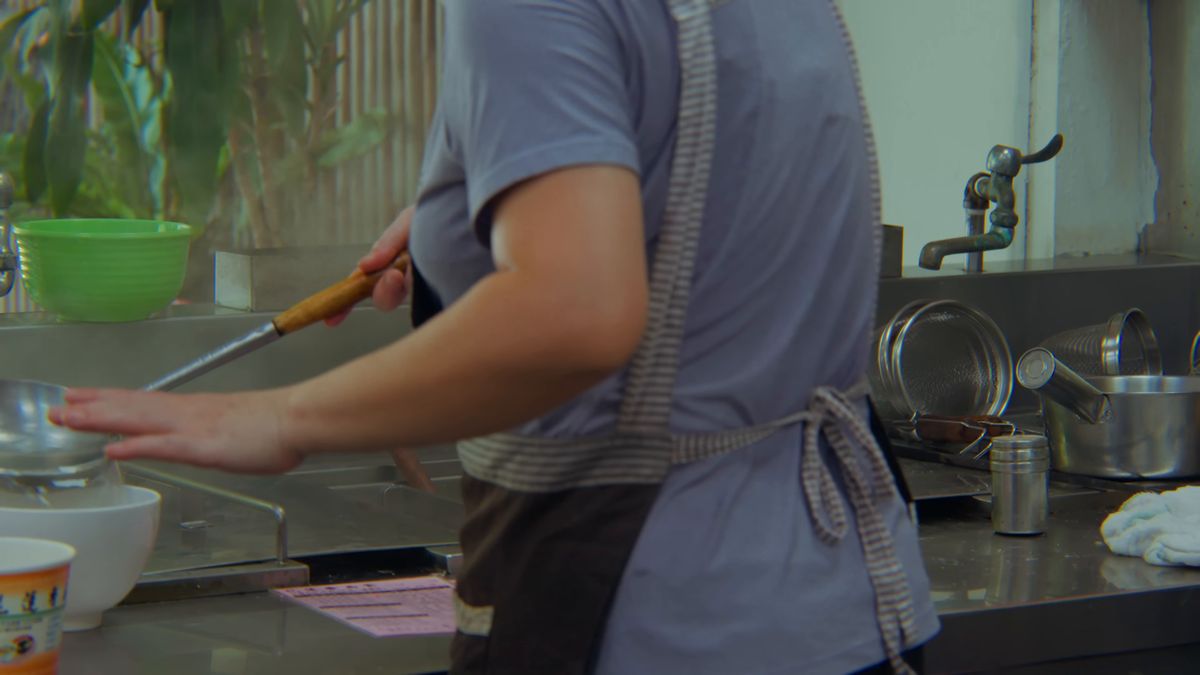 鍋で扁食を茹でる店の人の手元