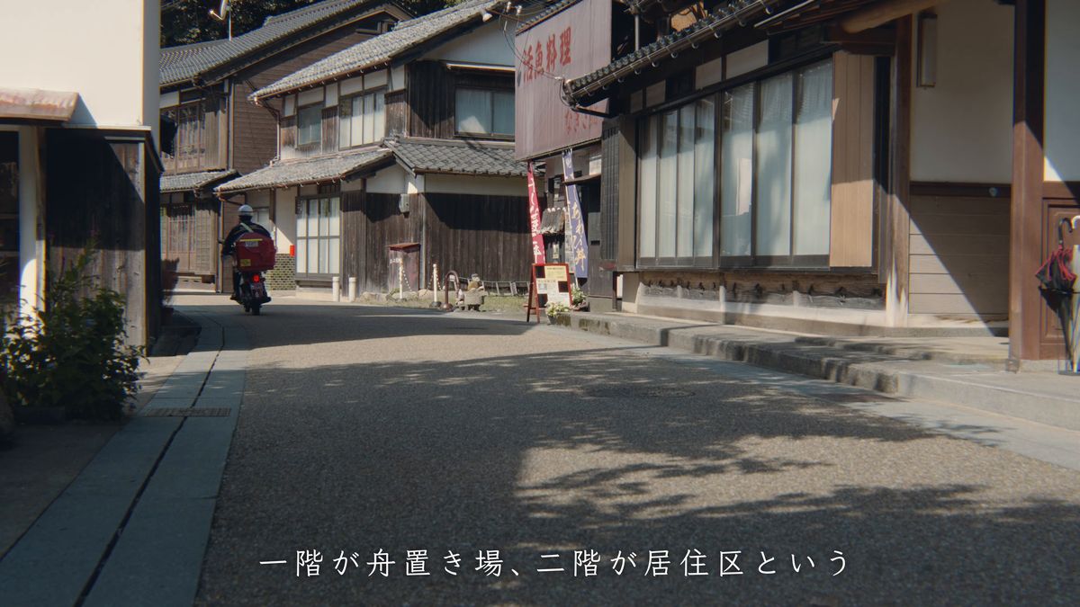 家並みの間の道を走るスクーター