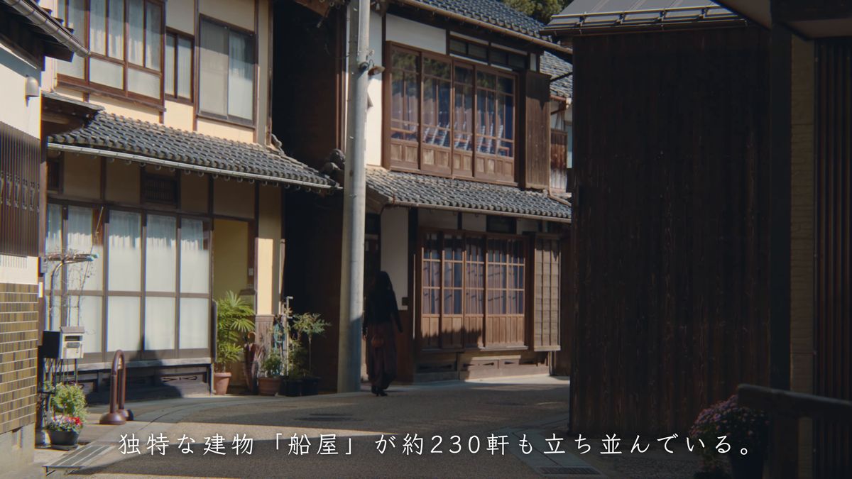 舟屋の裏手の路地を歩く後ろ姿