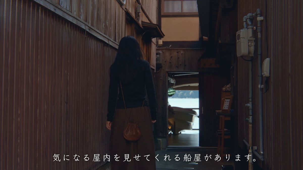 舟屋の暗い戸口へ入っていく後ろ姿