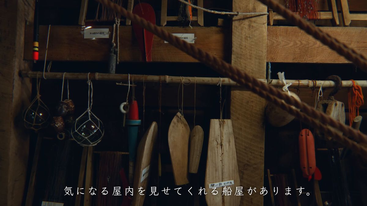 梁から下がるロープと、壁に掛かった櫂や浮き