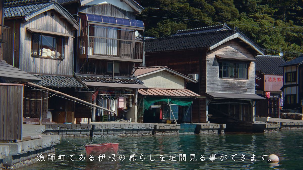 海から見た舟屋と、一階に干された洗濯物
