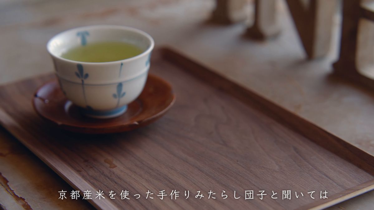 木の盆にのった緑茶の湯のみ