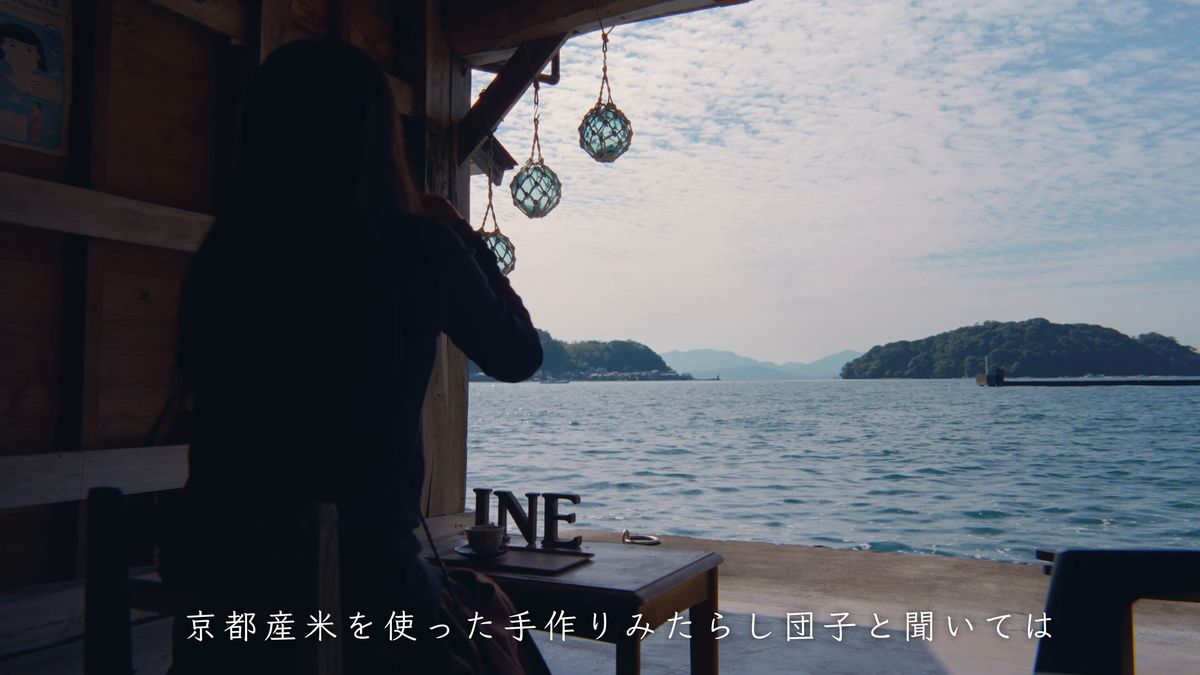 海に開いた席から湾を眺める後ろ姿
