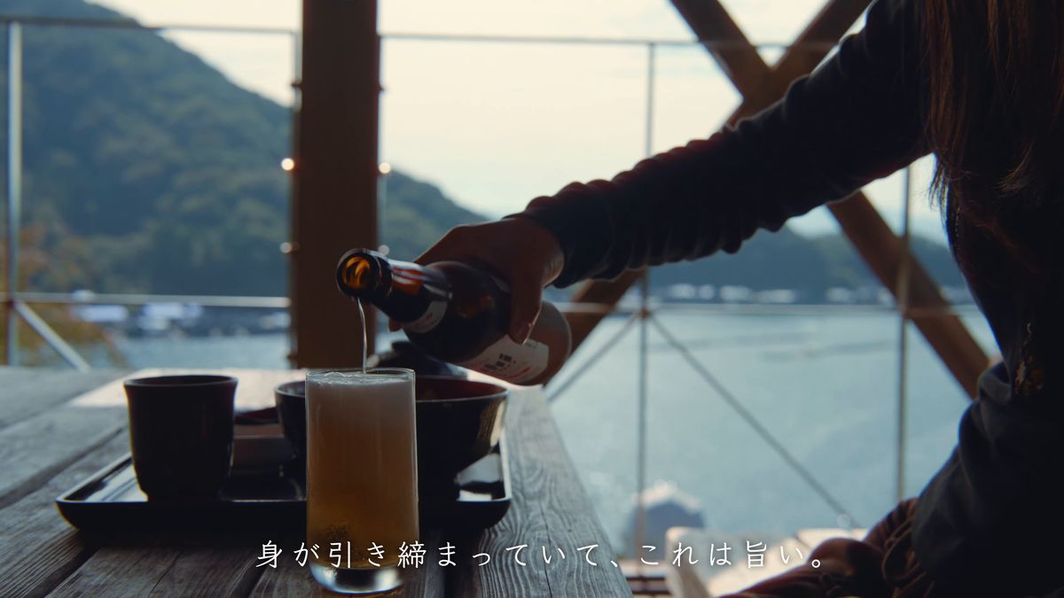 海を背に、グラスにノンアルコールビールを注ぐ