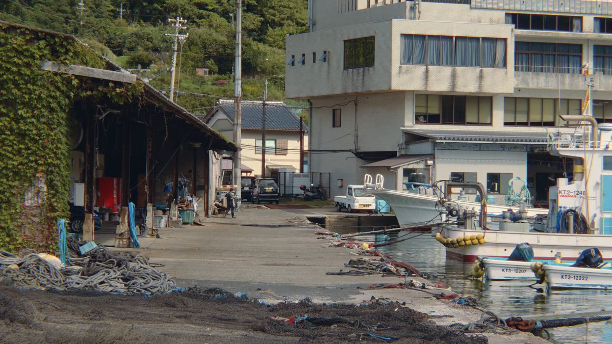 漁具の積まれた港の岸壁と、白い建物