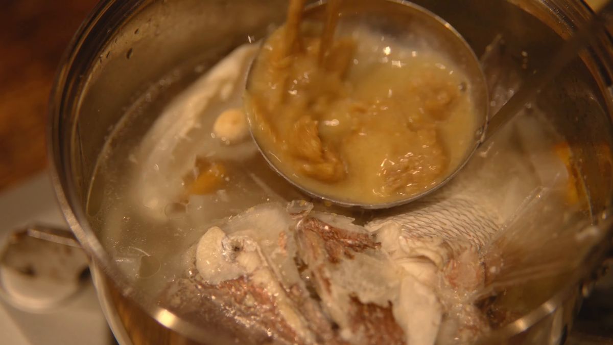おたまで鍋に調味料を加える