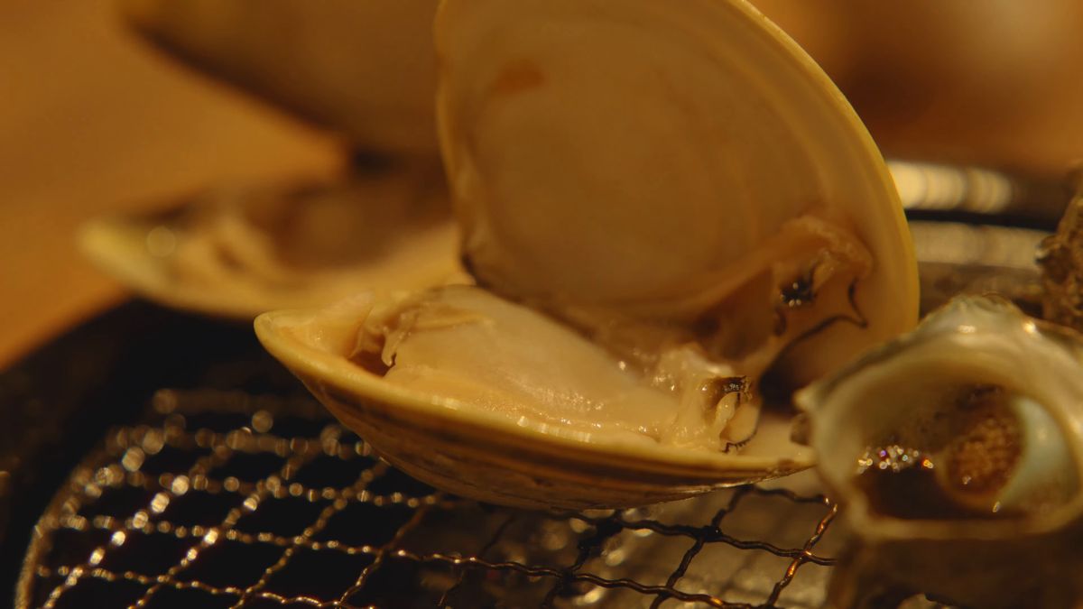 口を開けたハマグリと、隣で焼けるサザエ