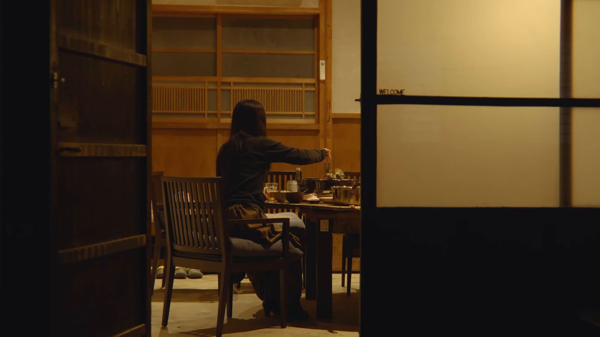障子の向こう、畳の間で食卓につく後ろ姿
