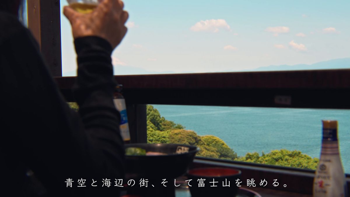 グラスを掲げる手と、窓の外の海